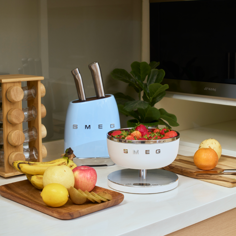 Kitchen counter with fruit, a SMEG knife block, and a SMEG bowl.